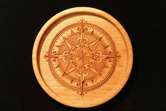 Round cherry wood tray carved with an ornate vintage compass rose medallion with fleur-de-lis points