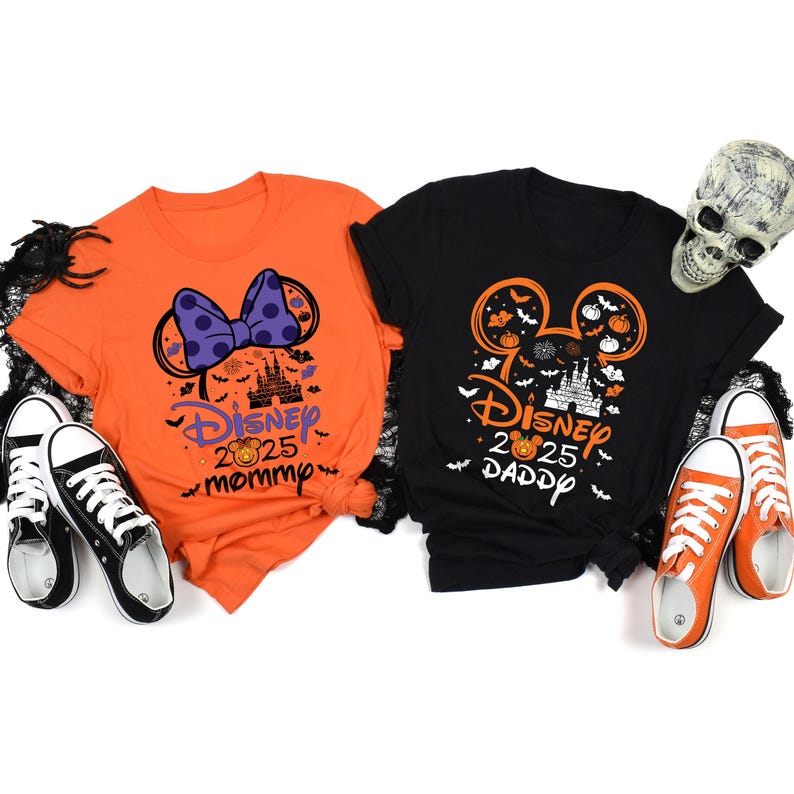 May include: Two Halloween-themed Disney t-shirts. One orange shirt features a Minnie Mouse bow design and the text "Disney 2025 Mommy". The other black shirt has a Mickey Mouse head design and the text "Disney 2025 Daddy".