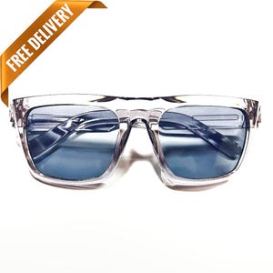 Puede incluir: Gafas de sol con montura transparente y lentes azules. Las gafas tienen forma cuadrada.