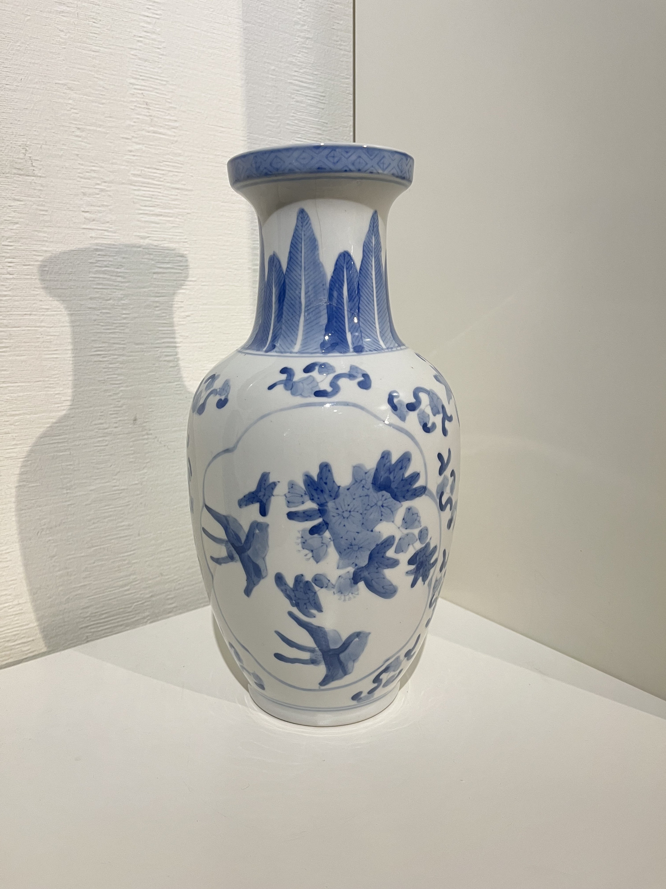 鳥と花のモチーフが特徴的な中国風磁器の花瓶。青と白。高さ 30 cm