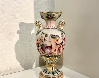 Vase amphore vintage avec poignées Capodimonte Putti Angelot peint à la main en haut relief et dans de belles couleurs pastel. Détails dorés. Signé.