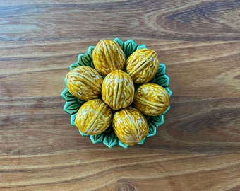 Majolica tromp l&#39;oeil green leaf dish with seven sculpted walnuts. Glazed ceramic. Hole at the back for hanging on the wall. Vintage.