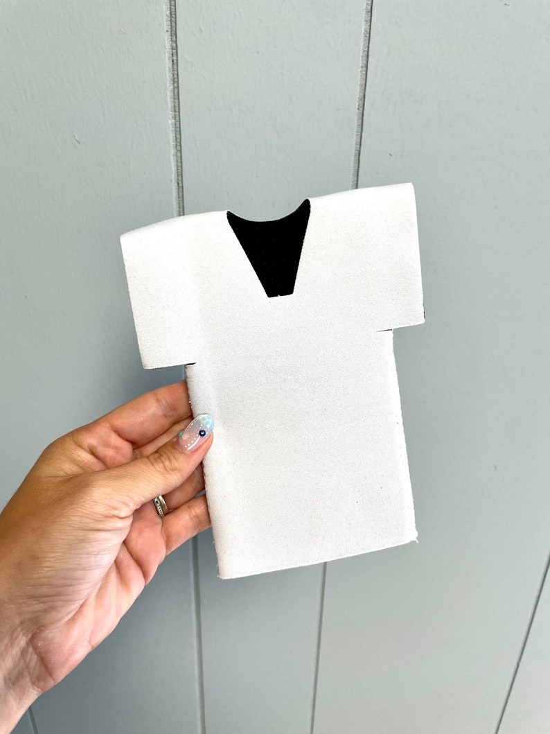 May include: White foam can cooler shaped like a doctor's scrubs with a black V-neck.