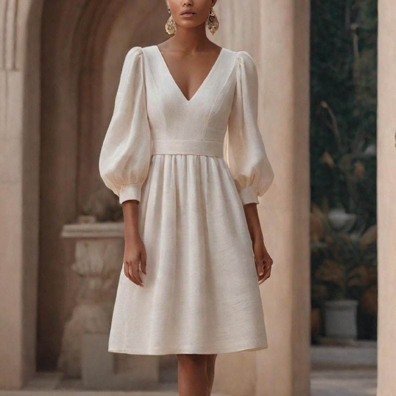 May include: A white dress with a v-neckline and 3/4 length sleeves. The dress has a fitted bodice and a flowy skirt.