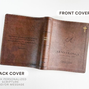 K&ouml;nnte beinhalten: Offener brauner Leder-Bibelumschlag mit goldenem Kreuz und personalisiertem Text. Der Umschlag tr&auml;gt den Namen "Armstrongs" und die Worte "Holy Bible". Die R&uuml;ckseite bietet Platz f&uuml;r personalisierte Schrift.