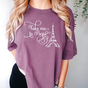 May include: A purple t-shirt with the text "Take me to Paris" and a white outline of the Eiffel Tower.