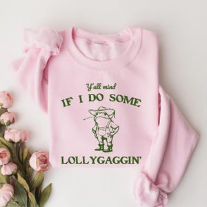 May include: Pink sweatshirt with a green frog graphic and the text "Y'all mind if I do some lollygaggin'"