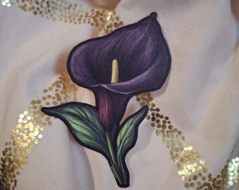 May include: A dark purple calla lily with green leaves. The flower is drawn in a realistic style.