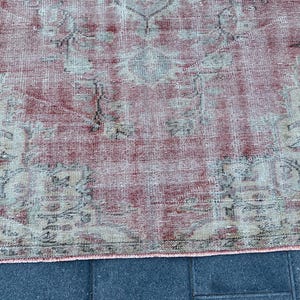May include: A vintage rug with a faded pink and cream color scheme. The rug has a traditional Persian design with intricate floral patterns.