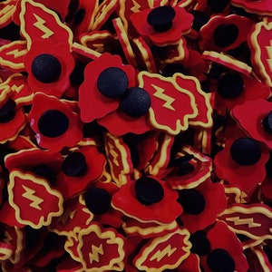 May include: A close-up of a pile of red and yellow lightning bolt shaped resin buttons. The buttons have a black center and are perfect for adding a pop of color to any project.