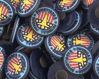Peut inclure: Gros plan sur un tas de boutons ronds bleus et blancs avec le texte "PHYSICAL FITNESS EXCELLENCE" et une silhouette jaune avec des étoiles. Les boutons ont un design à rayures rouge, blanc et bleu.
