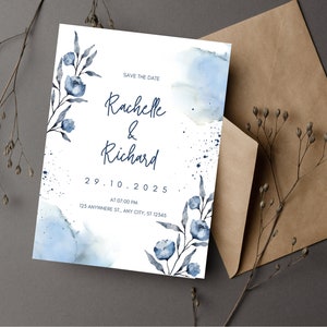 Puede incluir: Tarjeta de guardar la fecha con un fondo de acuarela en tonos azules y blancos. La tarjeta presenta un diseño floral con flores y hojas azules. El texto en la tarjeta dice "Save the Date", "Rachelle & Richard", "29.10.2025", "AT 07:00 PM", y "125 ANYWHERE ST., ANY CITY, ST 12545".