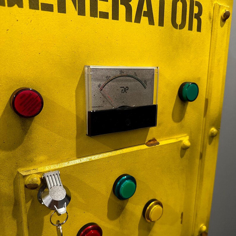 May include: Yellow metal box with the word "GENERATOR" printed in black. The box has a round red button, a round green button, a round black button, a round gray button, a key, and a round analog gauge with a black needle and the text "25h, 50h, 75h" printed on the face.