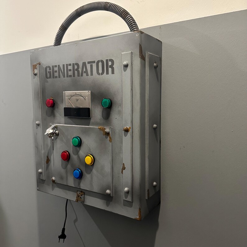May include: A gray metal box with the word "GENERATOR" printed on it. The box has a variety of buttons and a keyhole. There is a black electrical cord plugged into the box.
