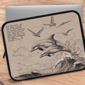 May include: Laptop sleeve featuring a sepia-toned illustration of dolphins leaping from ocean waves, with birds soaring above. The design includes text from Genesis 1:20. The sleeve has a black border and a zipper closure.