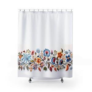 May include: White shower curtain featuring a vibrant floral design. The bottom border showcases colorful flowers in shades of blue, orange, red, and pink, with green leaves and stems. The curtain hangs from silver hooks.