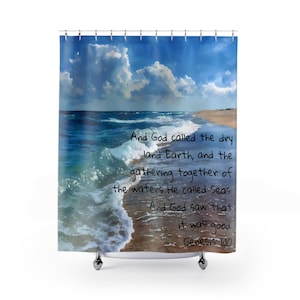 May include: A shower curtain featuring a serene ocean scene with blue waves, a sandy beach, and a bright sky with fluffy white clouds. The text "And God called the dry land Earth...Genesis 1:10" is printed on the curtain.