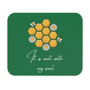May include: A green square coaster with a honeycomb design, daisies, and bees. The text "It is well with my soul" is written in a cursive font. The coaster is a decorative item.