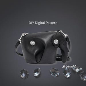 K&ouml;nnte beinhalten: Schwarze, lederne, elefantenf&ouml;rmige Handtasche mit silbernen Beschl&auml;gen und Strasssteinen. Die Tasche hat einen Rei&szlig;verschluss und einen Schulterriemen. Der Text "DIY Digital Pattern" steht &uuml;ber der Tasche. Mehrere klare Kristalle sind darunter.