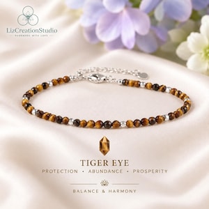May include: A delicate bracelet featuring faceted brown and gold tiger eye gemstone beads interspersed with small silver-toned metallic spacers. The jewelry piece includes a silver-toned lobster claw clasp and an adjustable chain extension.