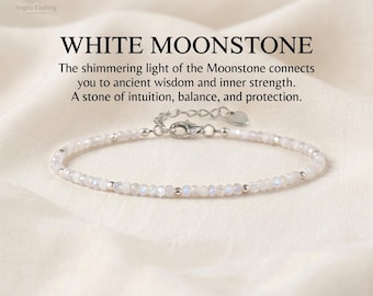 May include: A delicate bracelet featuring small, faceted white moonstone beads interspersed with tiny silver-toned metal spheres. The piece includes a silver-toned lobster claw clasp, an adjustable chain extension, and a small heart-shaped charm.