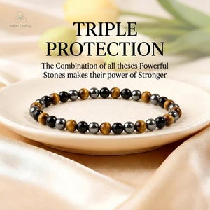 May include: A bracelet made of black, brown, and grey beads, presented on a white plate. The image includes the text "TRIPLE PROTECTION". The text below reads "The Combination of all theses Powerful Stones makes their power of Stronger".