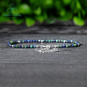 May include: A delicate anklet made with small blue and green gemstone beads and a silver clasp.