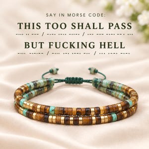May include: A double-strand bracelet featuring alternating brown tiger eye, turquoise, and gold-tone cylindrical beads with a green cord closure. The text above reads: SAY IN MORSE CODE: THIS TOO SHALL PASS / BUT FUCKING HELL.