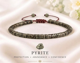 May include: A bracelet made of small, metallic, disc-shaped pyrite beads with a dark maroon adjustable cord closure. Below the bracelet is a single raw pyrite stone and the text: PYRITE PROTECTION • ABUNDANCE • CONFIDENCE AMPLIFY YOUR INTENTIONS.