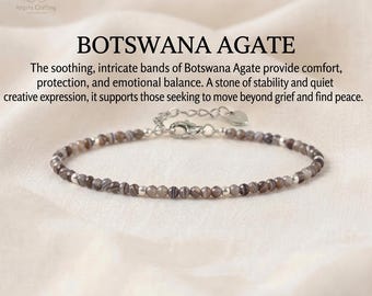 May include: A delicate bracelet featuring small, faceted Botswana Agate beads in shades of gray and brown, interspersed with tiny silver-toned metal spacers. The bracelet includes a silver-toned lobster clasp and an adjustable chain with a heart charm.