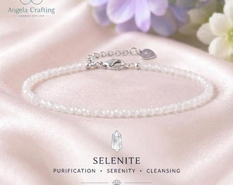 May include: A delicate bracelet made of small, faceted white selenite beads. The bracelet features a silver-toned metal clasp and an adjustable chain with a small heart-shaped charm. Text on the image reads Angela Crafting, Selenite, Purification, Serenity, Cleansing, Balance & Harmony.