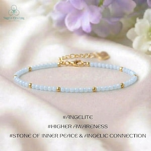 Könnte beinhalten: Ein zartes Armband mit kleinen hellblauen Perlen, die mit winzigen goldfarbenen Metallkugeln durchsetzt sind. Das Schmuckstück verfügt über eine goldfarbene Verlängerungskette und einen Karabinerverschluss. Der Text auf dem Bild lautet #ANGELITE #HIGHER AWARENESS #STONE OF INNER PEACE & ANGELIC CONNECTION.