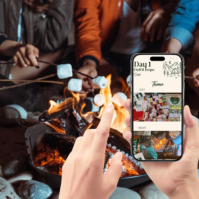 May include: A smartphone displaying a mobile app with the text "Day 1 Outfit Inspo" and a theme selection for day and night. The phone is being held by a hand in front of a campfire with people toasting marshmallows.