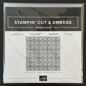 May include: A square Stampin' Cut & Emboss 3D embossing folder in clear plastic packaging. The label features the text 'STAMPIN' CUT & EMBOSS' and 'TIN TILE 3D EMBOSSING FOLDER' above a repeating grey and white geometric floral tile pattern.