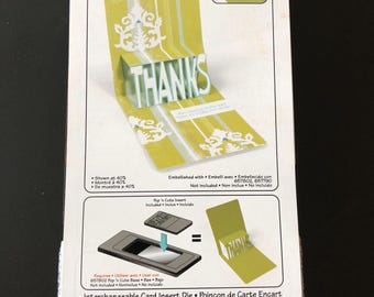 May include: A Sizzix Pop 'n Cuts insert die package. The package features a green and white card with the word "THANKS" in a 3D pop-up design. The package also includes a die and a card base.