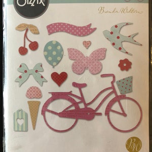 May include: A Sizzix Thinlits die set featuring 14 dies for crafting. The dies include a bicycle, a butterfly, a heart, a bow, a cherry, a balloon, a bird, and a banner. The dies are made of metal and are designed to be used with a die-cutting machine. The package is labeled with the Sizzix logo, the Thinlits logo, and the Brenda Walton logo. The package also includes the text "14 DIES | 14 POINÇONS | 14 TROQUELES | 14 FUSTELLE | 14 ВЫРУБКИ | 14 STANZEN".