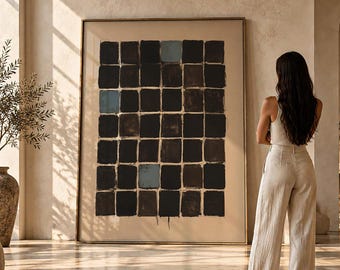 May include: A large rectangular framed wall art piece featuring a grid of dark brown and black squares on a beige background, with a few scattered light blue squares. The artwork is displayed in a room with neutral tones and natural light.
