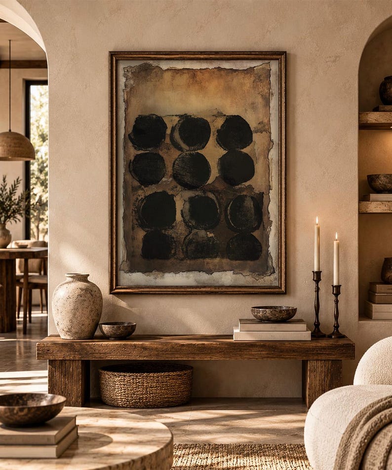May include: A rectangular framed wall art piece featuring a grid of nine dark black circles set against a textured, layered background of muted brown, tan, and cream tones. The artwork is enclosed in a thin, dark metallic frame with a weathered finish.