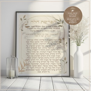 Puede incluir: Impresión enmarcada con texto hebreo e ilustraciones botánicas. La obra presenta un jarrón blanco con hierba alta y una linterna decorativa. La impresión se titula "Hafrashat Challah Prayers".