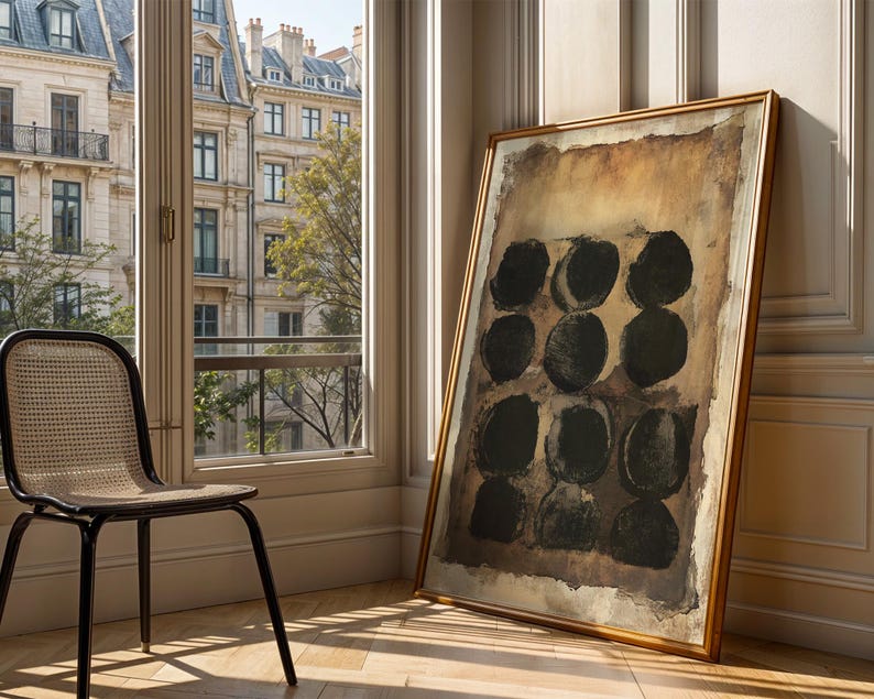 May include: A large rectangular framed painting featuring a grid of nine dark black circles arranged in three rows of three. The background of the artwork consists of layered shades of brown, tan, and beige with a textured, weathered appearance.