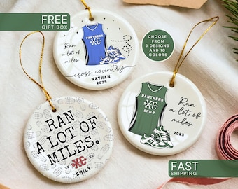 May include: Three round white ceramic ornaments with gold hanging strings. Two feature a cross country jersey, running shoes, the text "Ran a lot of miles," "cross country," a name, and "2025." One features "RAN A LOT OF MILES," a shoe print pattern, and "2025."