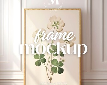 May include: A gold frame mockup with a white background and a floral illustration of white flowers and green leaves. The text "frame mockup" is written in white letters on the image. The text "ISO DIN A RATIO" and "SMART OBJECT FOR PHOTOSHOP" are written in black letters at the bottom of the image.