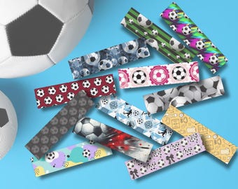 Peut inclure: Plusieurs bandes décoratives à motifs de ballons de football et de motifs abstraits. Deux ballons de football sont en arrière-plan. Les bandes sont disposées sur une surface bleu clair.