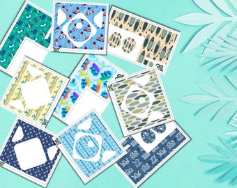 Peut inclure: Plusieurs cartes carrées à motifs avec divers motifs, notamment des astronautes, des kayaks et des formes abstraites. Les cartes ont une bordure blanche et sont disposées sur un fond bleu clair avec des feuilles découpées en papier.