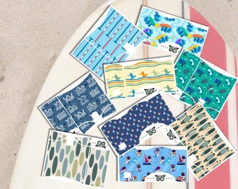 Peut inclure: Une collection de sous-vêtements à motifs avec divers motifs, notamment des lignes de natation, des surfeurs et des astronautes. Les sous-vêtements présentent un motif de papillon et sont présentés sur une planche de surf sur un fond sablonneux. La palette de couleurs comprend des bleus, des verts et des jaunes.