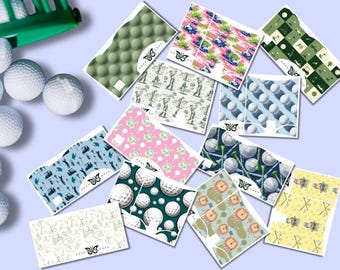 Peut inclure: Une collection d'autocollants rectangulaires sur le thème du golf présentant divers motifs incluant des balles de golf, des voiturettes, des clubs et des tees dans des tons rose, bleu, vert et jaune, disposés autour de balles de golf blanches.