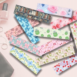 May include: A collection of decorative bookmarks with various patterns, including floral, fruit, and book-themed designs. The bookmarks feature pastel colors and whimsical illustrations, perfect for book lovers and stationery enthusiasts.