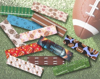 Peut inclure: Ensemble de marque-pages sur le thème du football avec divers motifs, dont des ballons, des fleurs et un design de terrain. Un ballon de football marron est visible en arrière-plan, sur un fond vert.