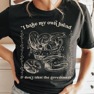 May include: Black t-shirt with a white graphic of a basket of bread and the text "I bake my own bread & don't trust the government".