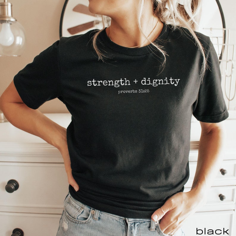 May include: Black t-shirt with white text that reads "strength + dignity proverbs 31:25"